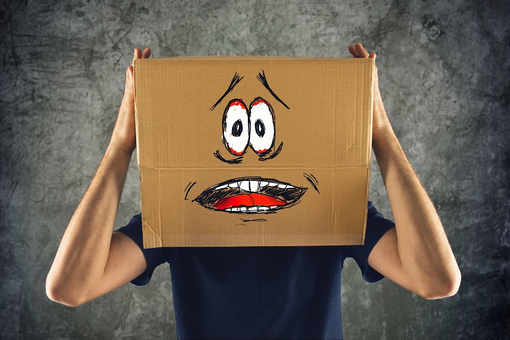 Man with cardboard box on his head and terrified look skethed